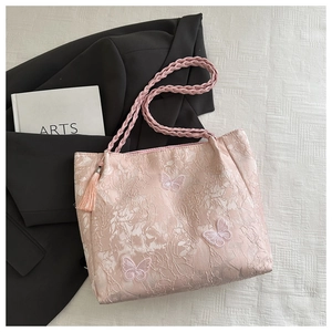 Close-up of pink jacquard tote bag with 3D butterfly embroidery and fringe detail