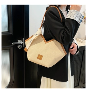 Detail of canvas tote bag with brown leather trim and fashion ribbon strap decoration