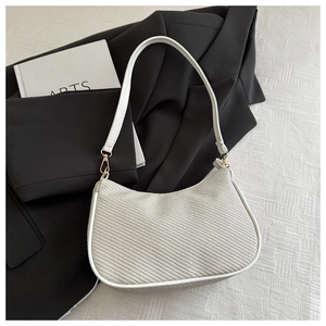Detail of off-white woven texture underarm hobo bag with gold hardware and leather trim