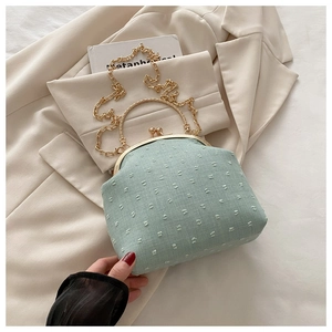 Dettaglio borsa jacquard verde menta con manico ad anello dorato e chiusura in metallo