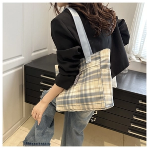 Detail of yellow and blue plaid tote bag with wide strap for daily commuting