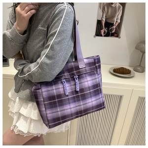 Detail of purple checkered tote bag featuring woven rope knots and wide shoulder strap