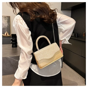 Detail of elegant champagne gold handbag with sparkling diamond-encrusted flap and chain