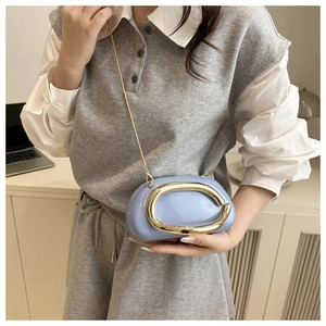 Détail d'un sac bandoulière rond bleu clair avec logo C doré et bandoulière chaîne