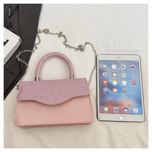 Detailed view of pink sequined handbag with silver chain strap and size comparison