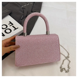 Detailed close-up of a pink rhinestone mini handbag with silver chain for evening wear
