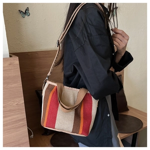 Détail du sac cabas tissé à rayures multicolores avec bandoulière réglable et texture