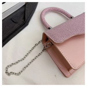 Detail of pink glitter handle and sequin flap on elegant leather crossbody handbag