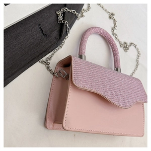 Detail of pink glitter flap and smooth leather texture on elegant crossbody handbag