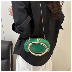 Macro detail of glossy green patent leather bag with a large golden circular handle
