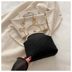 Dettaglio borsa vintage nera a pois con cornice dorata e tracolla a catena