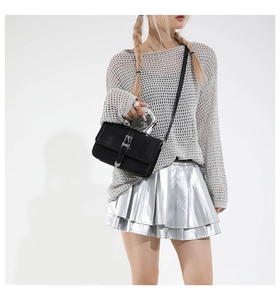 Detail of black leather crossbody bag with avant-garde silver metallic handle and buckle