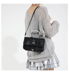 Detail of black matte leather shoulder bag with unique silver metal lip shaped handle