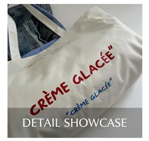Detail of white canvas tote featuring blue and red Crème Glacée French embroidery text