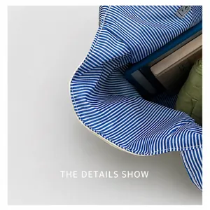 Detail view of canvas tote bag with blue striped lining and interior brand label