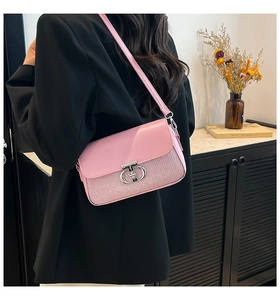 Vue latérale du sac rose à texture pailletée avec fermoir métallique argenté en T