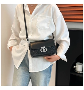 Détail du sac boîte noir avec texture pailletée et fermoir en métal argenté en T