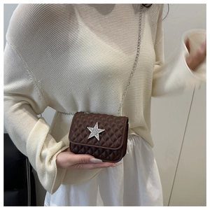 Détail d'un mini sac à chaîne matelassé marron foncé orné d'une étoile en strass sur le devant