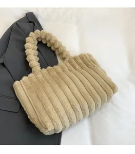 Detail of plush beige shoulder bag with unique faux fur pom-pom strap and striped texture
