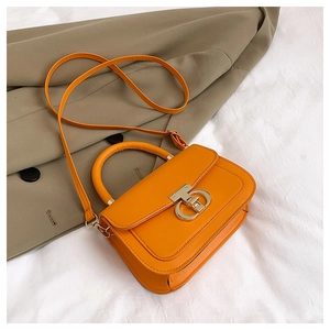 Vue détaillée du sac bandoulière orange vif avec fermoir argenté et cuir synthétique