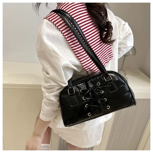 Detailed back view of a black patent leather shoulder bag with chic lace-up design details