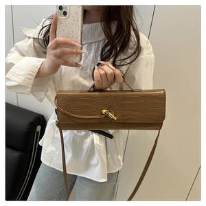 Borsa marrone con trama a coccodrillo e fibbia dorata mostrata in un selfie
