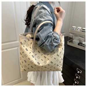 Detailed side view of beige large tote bag with bear print and sturdy shoulder straps