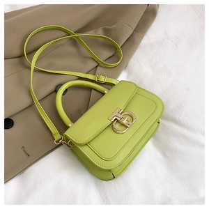 Détail du sac à main en cuir vert citron avec fermoir en métal doré en forme de T
