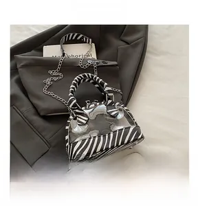 Detailed shot of transparent PVC shell bag with zebra print faux leather and silver chain strap