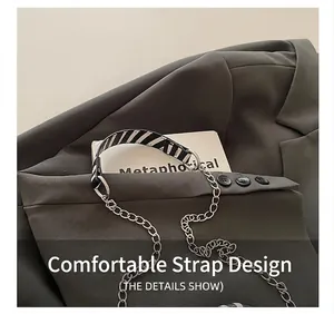 Detail of black and white striped canvas strap with silver metal chain links on blazer
