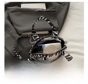 Detail showing the inner capacity of this zebra print crossbody bag with cosmetics