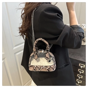 Mini-Muscheltasche mit Schlangenmuster und transparentem PVC-Panel am Modell gezeigt