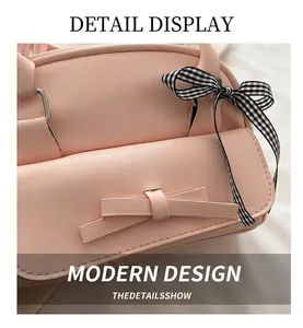 Detail of pink PU leather shell bag featuring a bow design and black white checkered ribbon