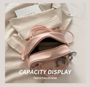 Detail view of pink bow handbag interior capacity with wallet on a stylish background