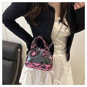 Detail of transparent PVC shell bag with pink snake pattern leather and silver chain strap