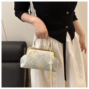 Detailed view of the Chinese style floral jacquard handbag with metal handle and tassel