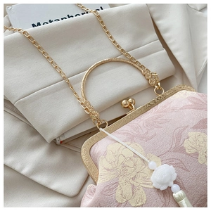 Dettaglio borsa a conchiglia con tessuto jacquard floreale rosa e nappina di loto