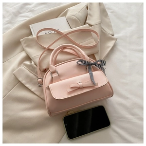 Pink PU leather Boston bag with ribbon bow detail and checkered scarf on handles
