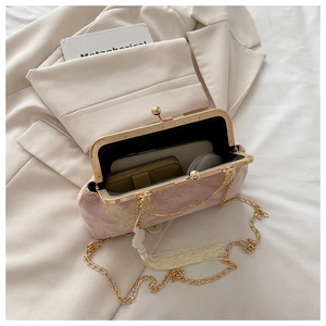 Borsa jacquard rosa a fiori con catena dorata e nappa che mostra lo spazio interno