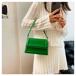 Detalle de bolso bandolera de ecopiel verde brillante con patrón de textura rectangular