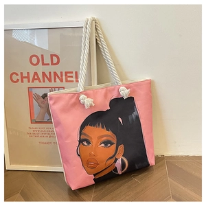 Gros plan du sac cabas en toile rose avec poignées en corde et imprimé artistique