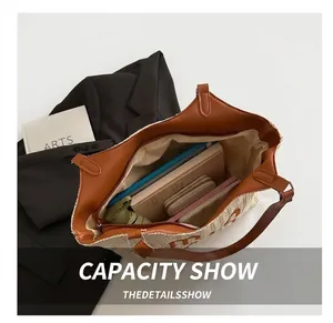 Top view of spacious interior of cream woven straw tote bag with brown leather details