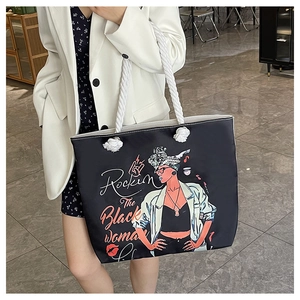 Détail du sac cabas noir avec illustration colorée et anses en corde blanche sur mannequin