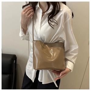 Detailansicht der hellbraunen Beuteltasche mit Metallic-Schleife und glänzendem Finish
