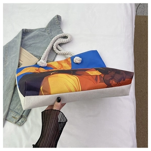 Détail du sac cabas en toile avec imprimé artistique éclatant et poignée en corde