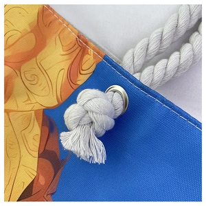 Détail de la poignée en corde de coton blanc et des œillets métalliques d'un sac de plage bleu