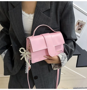 Pink crossbody bag with pearl lace bow detail and engraved Fashion lettering on side