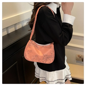 Detail of peach pink underarm bag with Chinese style bamboo leaf patterns and crescent shape
