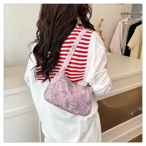 Detail of light pink floral shoulder bag with bamboo print worn as an underarm bag
