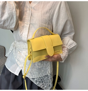 Detail of yellow crossbody bag with FASHION lettering and detachable strap